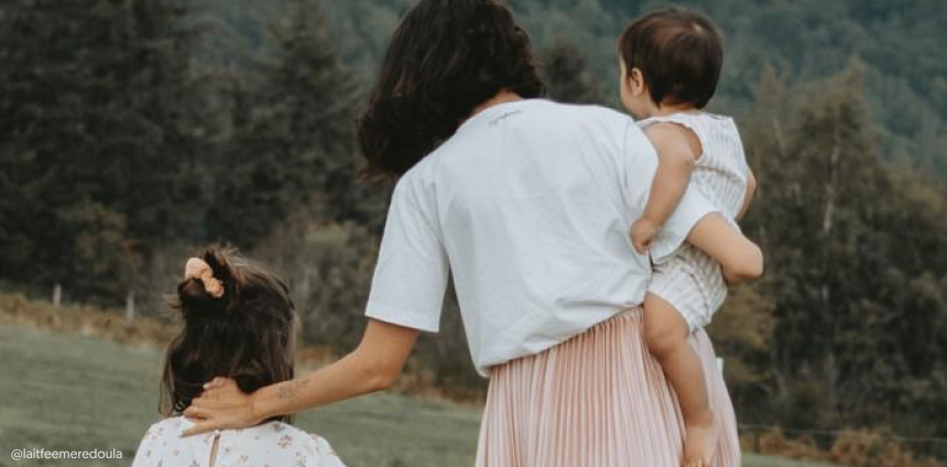 Une femme est de dos avec ses deux enfants. L'image comporte le copyright @laitfeemeredoula